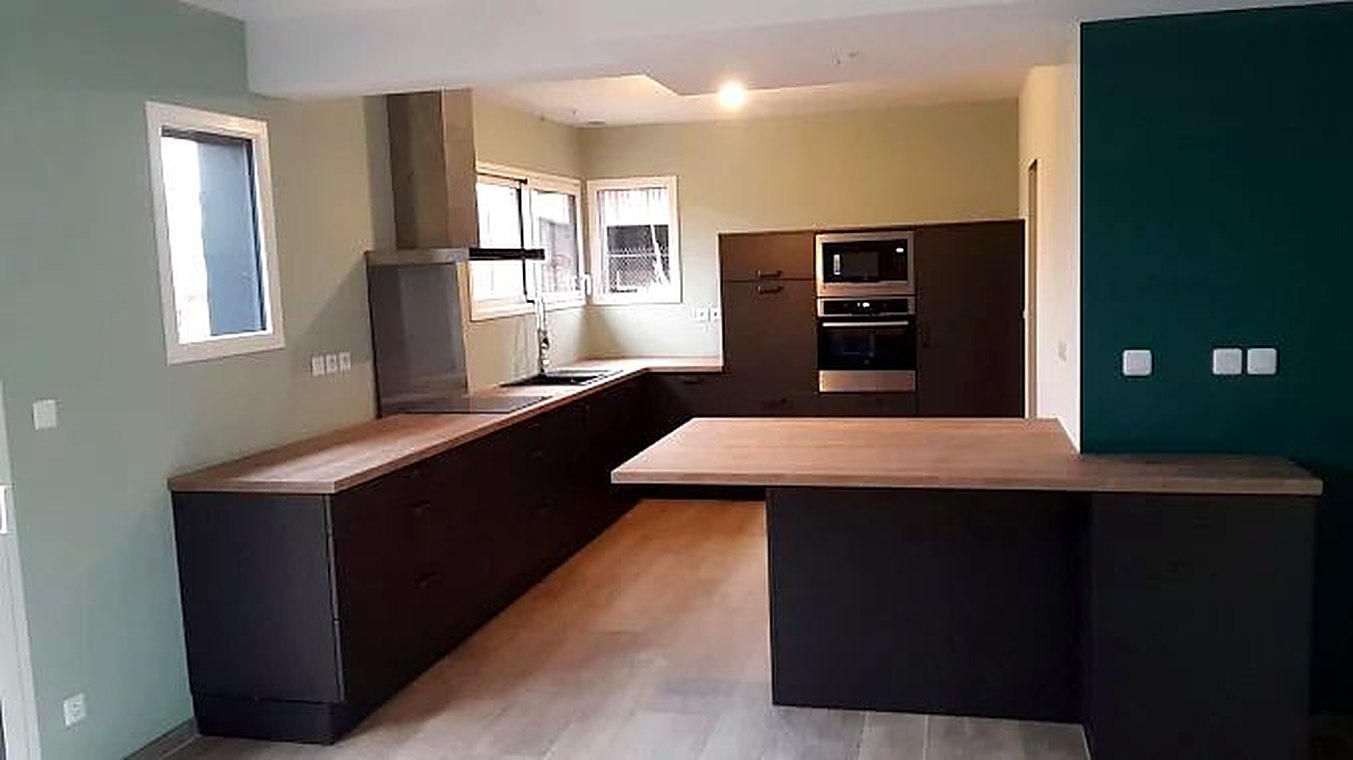 Cuisine anthracite avec îlot central et mur vert
