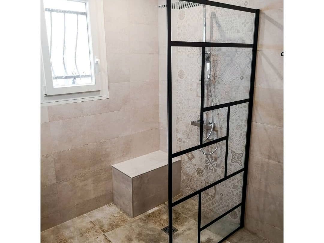 Paroi de douche verrière noire et carreaux de ciment