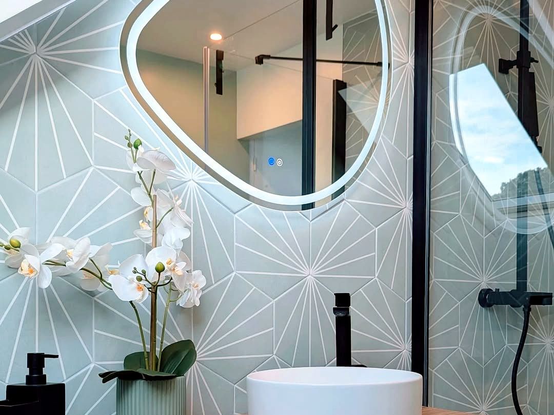 Miroir LED organique et vasque ronde sur carrelage hexagonal