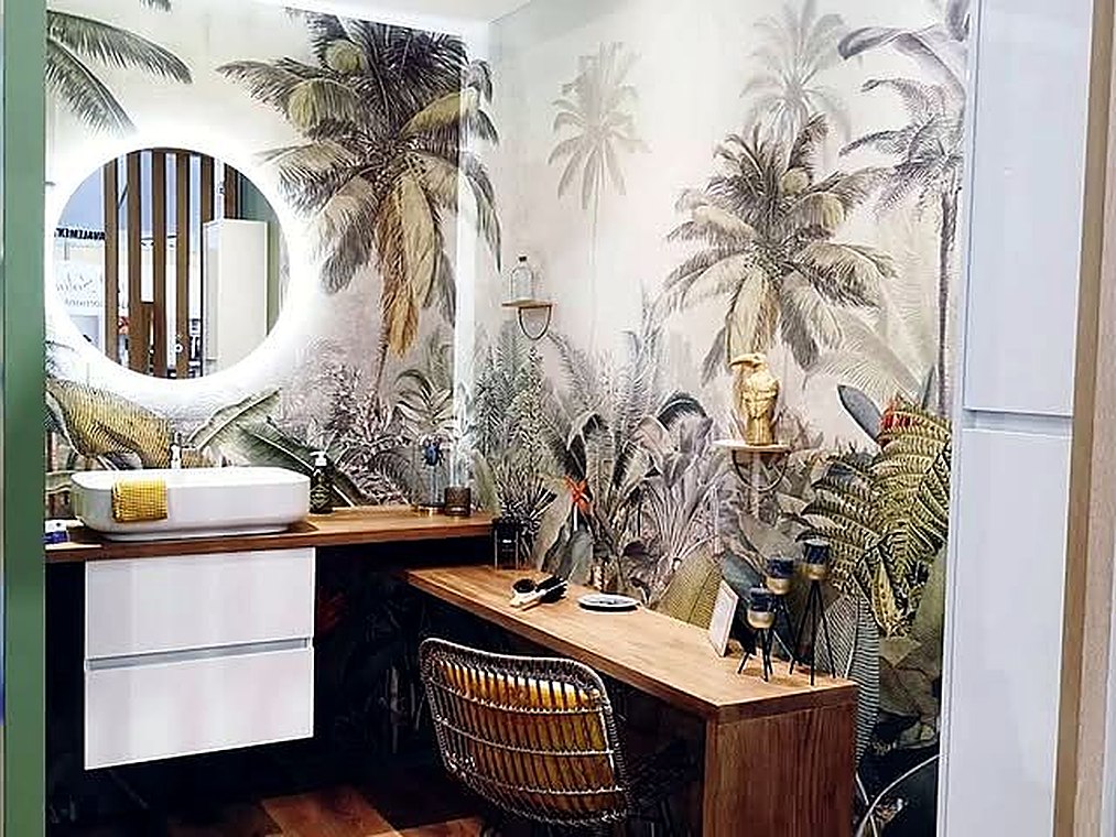 Salle de bains avec papier peint tropical et miroir rond rétroéclairé